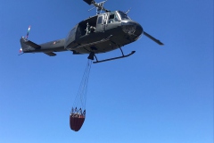 Un-UH-205-si-dirige-verso-un-incendio-trasportando-lacqua-nella-benna